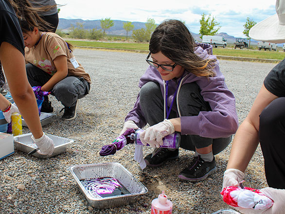 camper adding colors to their tie dye tee shirt