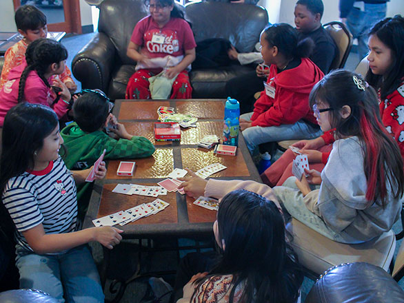 capmpers sitting around table playing cards