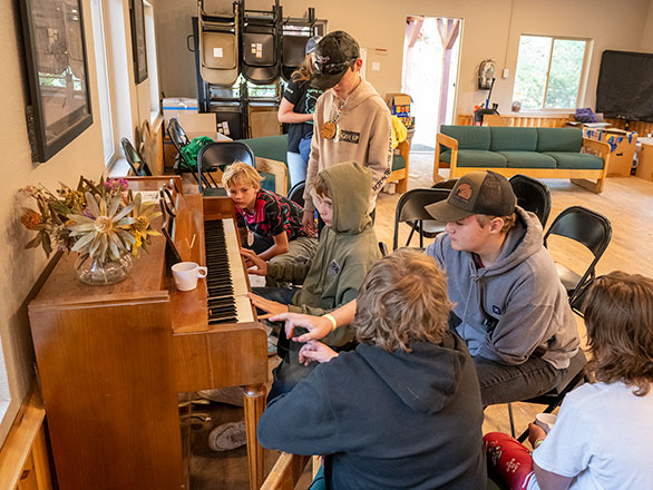 campers gathered around the piano singing songs
