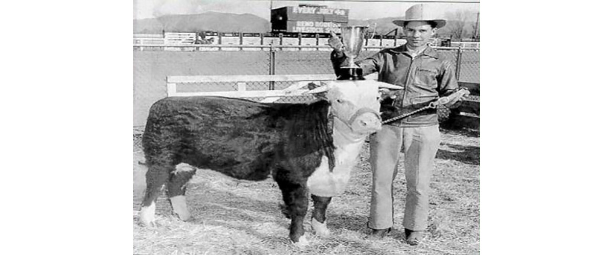 Young man holding trophy and prize winning calf.